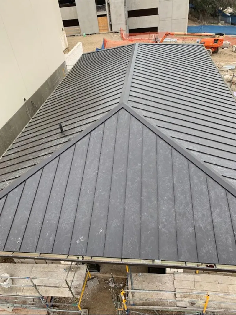 Commercial metal roof construction with crane equipment in Three Oaks