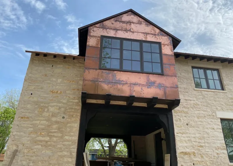 Copper metal panel facade on a stone building for Skylight Installation in Three Oaks